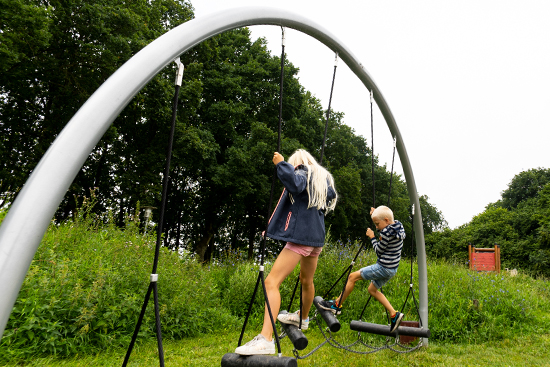 two children crossing a set of balancing logs